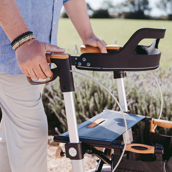 Close-up of a man's hands on a Saljol rollator fitted with the padded backstrap